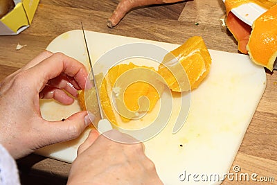 Cutting a peeled orange with sharp knife Stock Photo