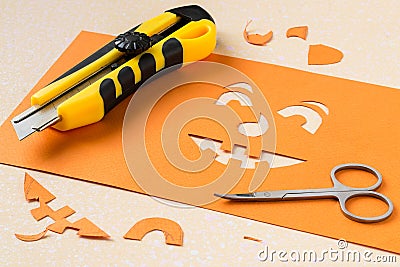 Cutting a stencil of paper for jack-o'-lantern Stock Photo