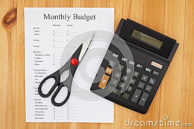 Cutting your monthly budget with a calculator and scissors Stock Photo