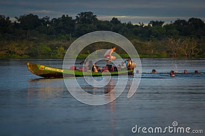 CUYABENO, ECUADOR - NOVEMBER 16, 2016: Young Tourists Jumping Into The Lagoon Grande Against The Sunset, Cuyabeno Editorial Stock Photo