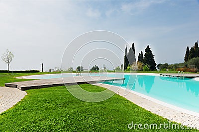 Cyan blue water pool next grass meadow Stock Photo