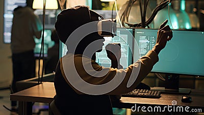 Cyber criminal using virtual reality haeadset to hack computer firewall Stock Photo