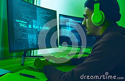 Cyber, gaming and a man with a computer for hacking, streaming music or working on phishing. Serious, dark and a hacker Stock Photo