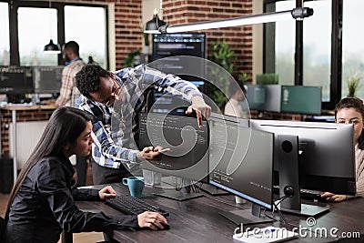 Cyber security agency coworker indicating on screen high usage of processing power on data grid information. Stock Photo