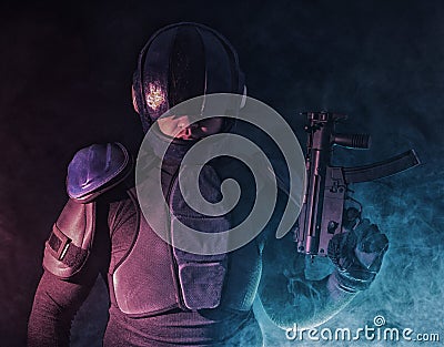 Cyberpunk concept, future world. Police officer cop in dark, halfman bionic cyborg or reloads gun, twitches cocking lever, Stands Stock Photo