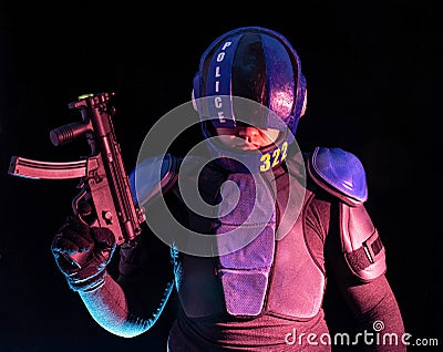 Cyberpunk concept, future world. Police officer cop in dark, halfman bionic cyborg or reloads gun, twitches cocking lever, Stands Stock Photo