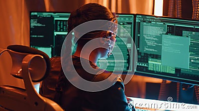 Cyberpunk girl backview types on keyboard multiple monitors with strings of code Stock Photo