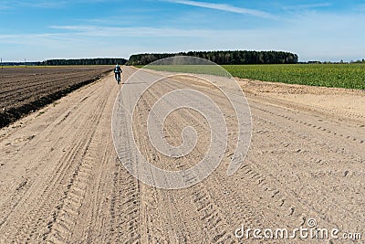 Cycling in nature. bike trip on a warm Sunny day on an empty dirt road. Road without cars along the forest. Weekend in nature with Stock Photo