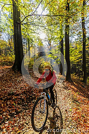 Cycling woman riding on bike in autumn. Stock Photo