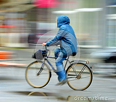 Cyclist on the city roadway in rainy day Stock Photo