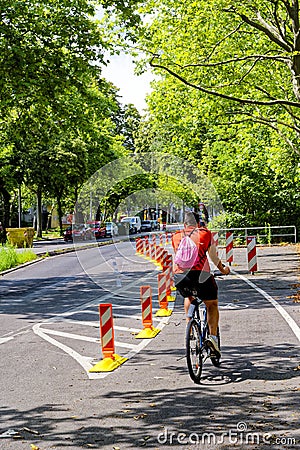 Cyclist in a dedicated cycle lane on a main road to improve road safety Editorial Stock Photo