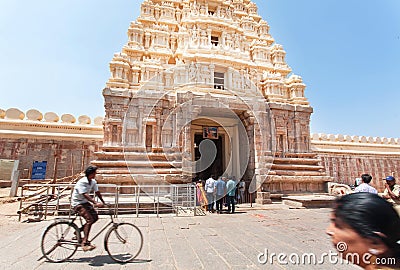 Cyclist driving past the 10th century Ranganthaswamy temple with carved gate gopuram Editorial Stock Photo