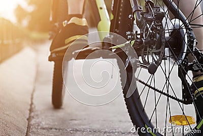 Cyclist legs on bicycle on street in sunset background Stock Photo