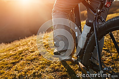 Cyclist legs riding mountain bike on the hill in spring time Stock Photo