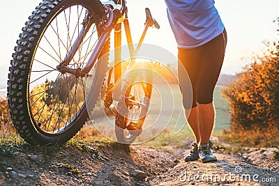 Cyclist man pushing a mountain bike up the hill close up image. Active travel on bicycle Stock Photo