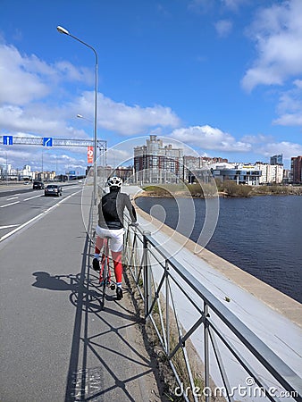 Cyclist resting by the railing next to the highway Editorial Stock Photo
