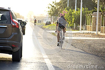 Cyclist ride bike on the road along cars passing beside him and keeping security distance with bicycles. Editorial Stock Photo