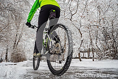 Cyclist rides in a beautiful winter park with snowy trees Stock Photo