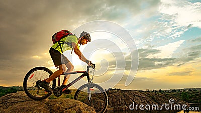 Cyclist Riding the Bike on Rocky Trail at Sunset. Extreme Sport and Enduro Biking Concept. Stock Photo