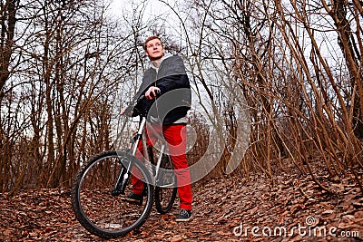 Cyclist Riding the Bike on the Trail in the Beautiful Spring Forest Wide Angle Stock Photo