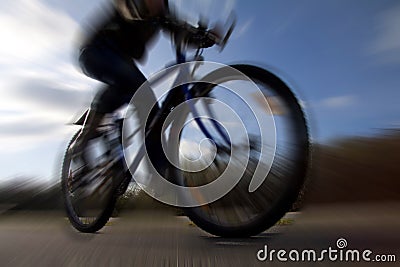 Cyclist riding on mountain bike in dramatic silhouette perspective and deliberately motion blurred Stock Photo