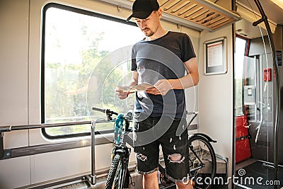 A cyclist or a tourist next to a bike at a special place for transporting bicycles. Stock Photo