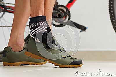 Cyclist tying mtb shoes near mountain bike Stock Photo