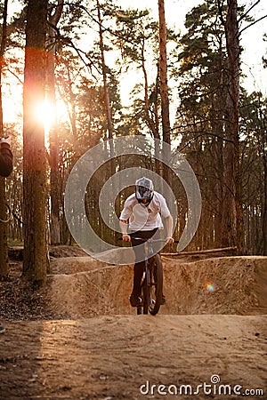 Cyclists in the forest on a track with slides for sport mountain Biking. Mountain bike jumping, extr Editorial Stock Photo