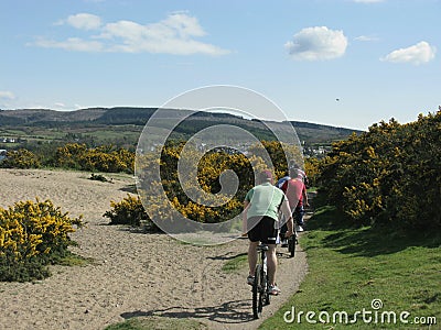 Cyclists on a sandy beach on the Isle of Arran, Scotland Editorial Stock Photo