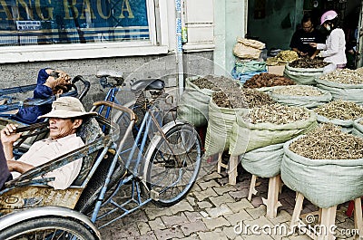 Cyclo taxi drivers and herbal shop in saigon city vietnam Editorial Stock Photo