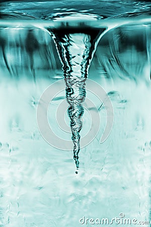 Cyclone demonstration in glass tube, tornado in water glass with rotating column of air, water tube with blue whirlpool Stock Photo