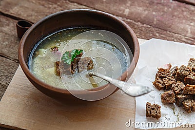 Czech garlic soup with homemade croutons close up in a bowl on the wooden board Stock Photo