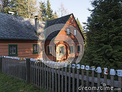 Czech Republic, Vlci Hora, November 30, 2019: Beautiful orange green wooden timbered house or cottage with fence covered Editorial Stock Photo