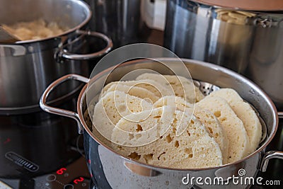 Czech yeast dumpling sliced into wheels and put into a steaming pot to keep the dumpling hot Stock Photo