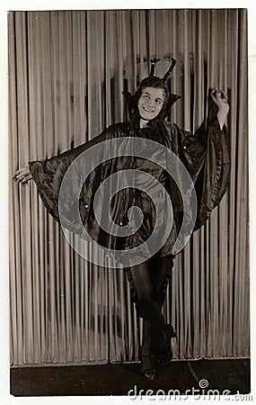 Vintage portrait photo shows young girl in a retro carnival costum (devil costum). Photo studio portrait, circa 1930s Editorial Stock Photo