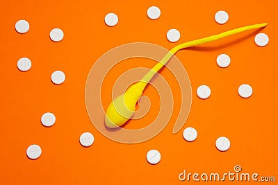 3D anatomical model of sperm cell or spermatozoon is on orange background surrounded by white pills ornament polka dots. Photo con Stock Photo