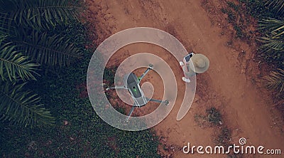 3D Animation. Technician farmer use wifi laptop control agriculture drone fly to sprayed fertilizer on the palm fields Stock Photo