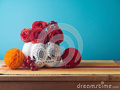 D­a de los Muertos day of the dead holiday concept. Sugar skull Halloween pumpkin and Mexican party decorations on wooden table Stock Photo