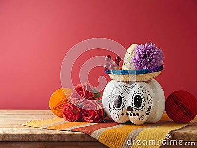 Da de los Muertos day of the dead holiday concept. Sugar skull Halloween pumpkin and Mexican party decorations on wooden table Stock Photo