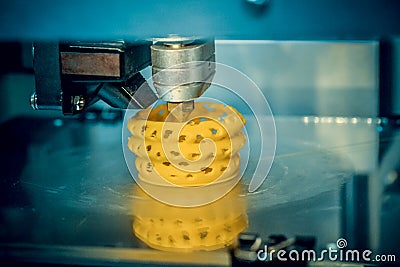 3d printer printing objects yellow form closeup. Stock Photo