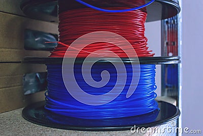 3D printing material, ABS filament, PLA & x28;Polylactic Acid& x29;, PVA Filament. Colored polymer in coils on the shelves Stock Photo