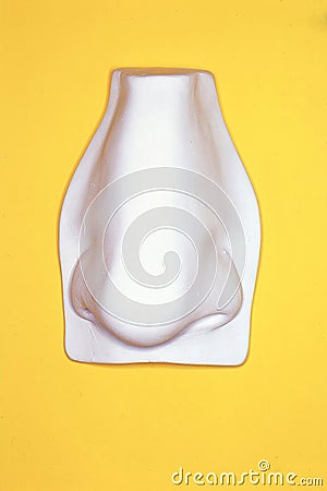 3D rendering of a human's droopy nose on a yellow background Stock Photo