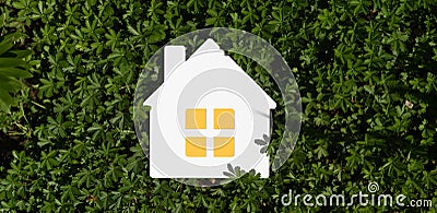 3d rendering of an implied flat lay design with a miniature white toy house on green grass Stock Photo