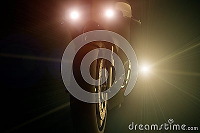 A motorcycle being chased by a bright light at night Stock Photo