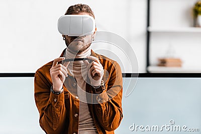 3d visualizer using virtual reality headset and holding stylus of graphics tablet near computer monitors Stock Photo