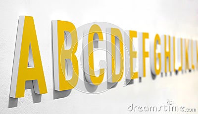 3d yellow alphabet lettering on a wall Stock Photo