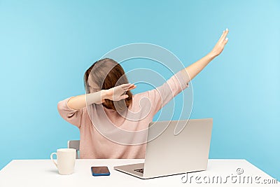 Dabbing trends. Overjoyed woman showing dab dance gesture, performing internet meme of success, sitting at workplace Stock Photo