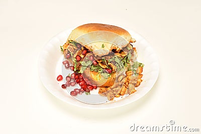 Dabeli is an Indian snack item served with Pomegranate Seeds and Cilantro in white ceramic plate. It`s a popular Street Food Stock Photo