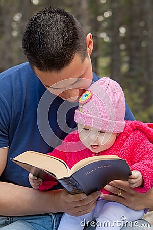 Dad and Baby Daughter Reading Bible Stock Photo