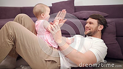 Dad with baby playing hands. Smiling father and toddler girl play with hands Stock Photo